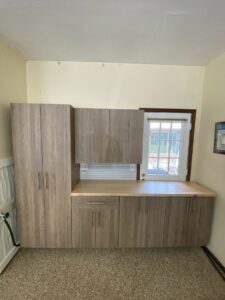 Custom garage cabinets with a wooden countertop and window installed by PremierGarage of Baltimore in Baltimore, MD.