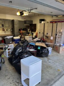 A cluttered garage filled with junk and bags before a cleanout service by Junk Lockdown LLC in Lancaster, PA.