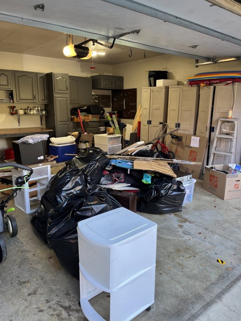 A cluttered garage filled with junk and bags before a cleanout service by Junk Lockdown LLC in Lancaster, PA.