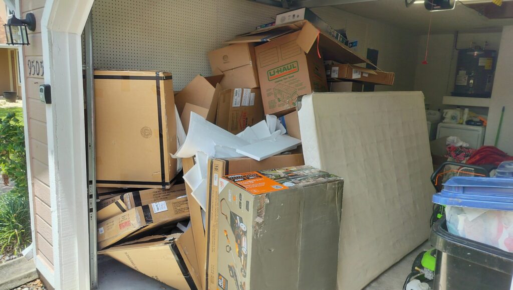A garage filled with cardboard boxes and an old mattress, ready for a cleanout by Westish Junk Removal LLC in Orlando, FL.