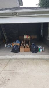 Items for a garage cleanout, including trash bags, boxes, and paint cans, ready for junk removal by Junken Monkeys Hauling Company in Scranton, PA.