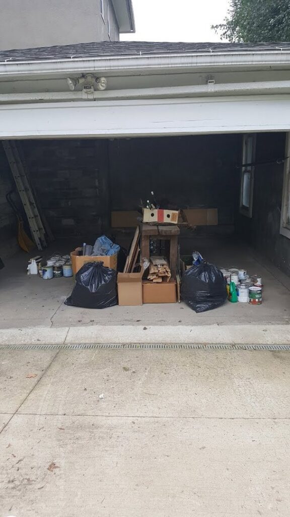 Items for a garage cleanout, including trash bags, boxes, and paint cans, ready for junk removal by Junken Monkeys Hauling Company in Scranton, PA.