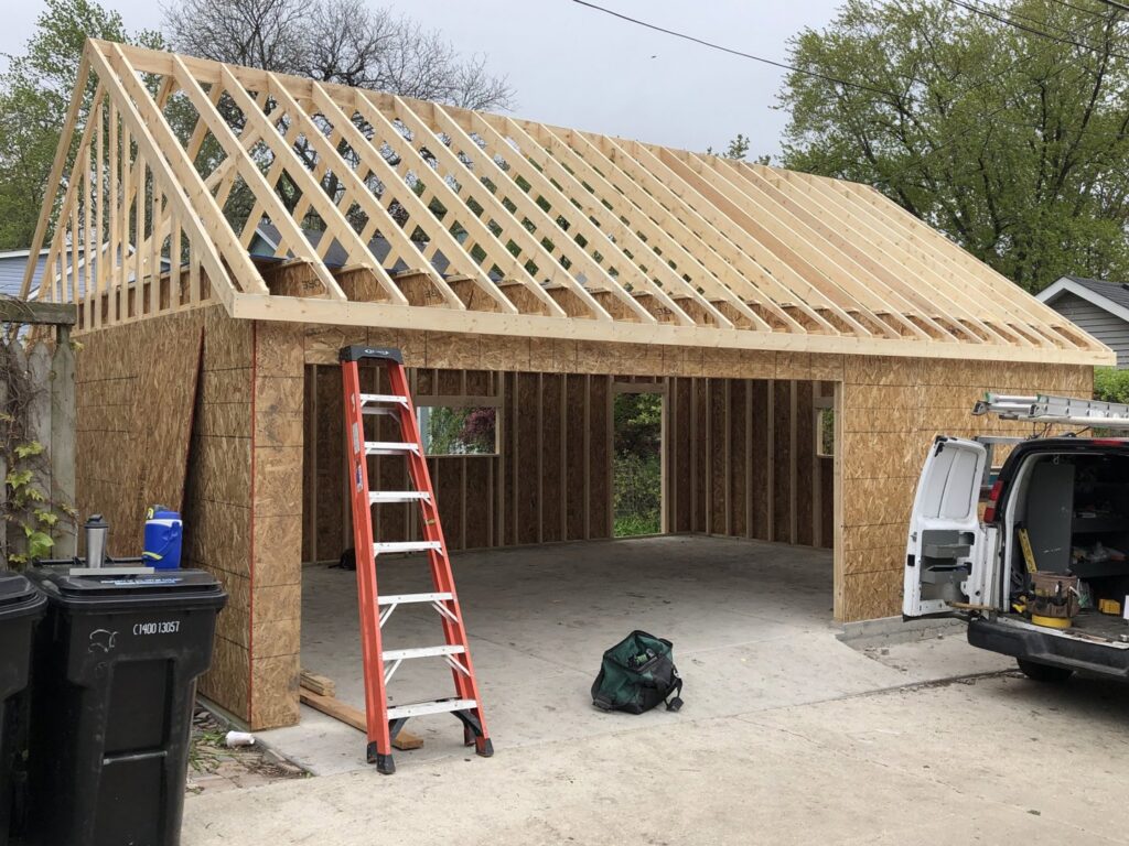 A garage under construction with wall framing and roof structure in place by A-Windy City Garages & Doors in Chicago, IL.