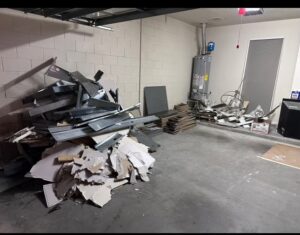 Piles of metal, drywall, and construction waste inside a garage for removal by The Removal Squad LLC in Orlando, FL.
