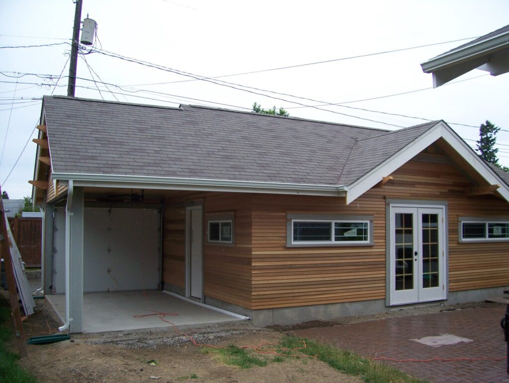 A garage under construction with wood siding and a new roof by Garages Etc in Tacoma, WA