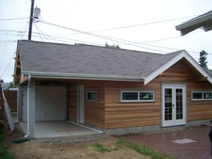 A garage under construction with wood siding and a new roof by Garages Etc in Tacoma, WA