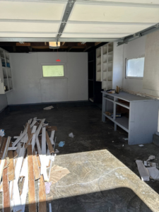 A garage floor covered in wooden debris, ready for cleanup by County Line Junk Removal in Saint Albans, WV.