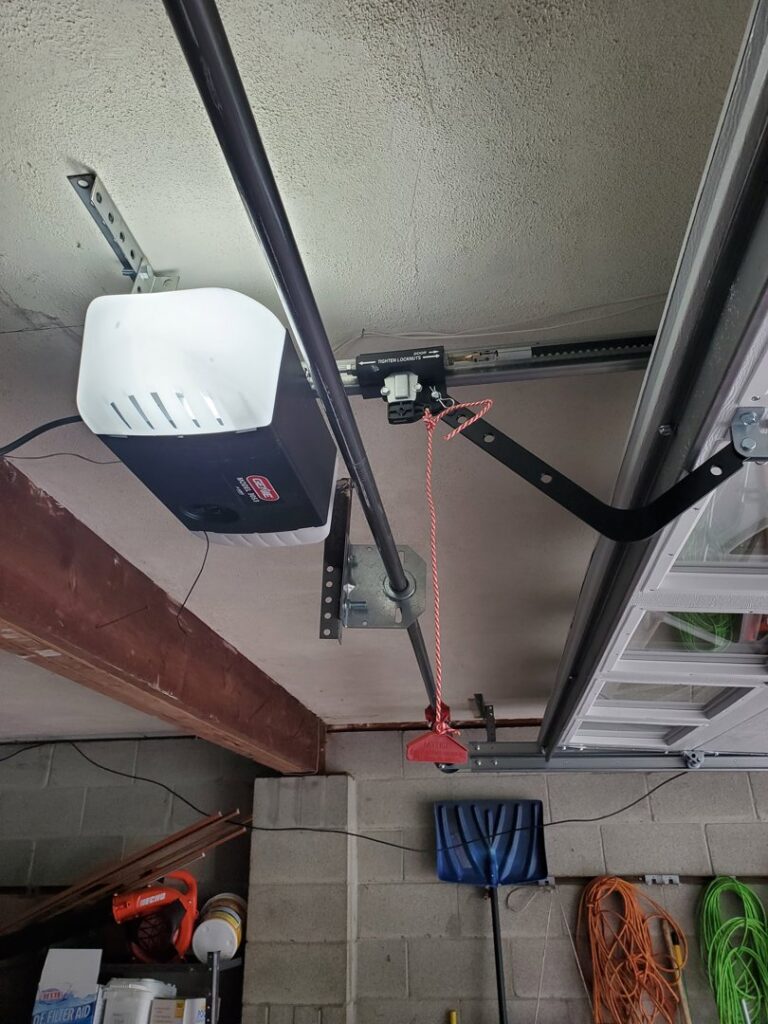 An installed garage door opener and tracks, showcasing work by Lucas Overhead Doors in Erie, PA.