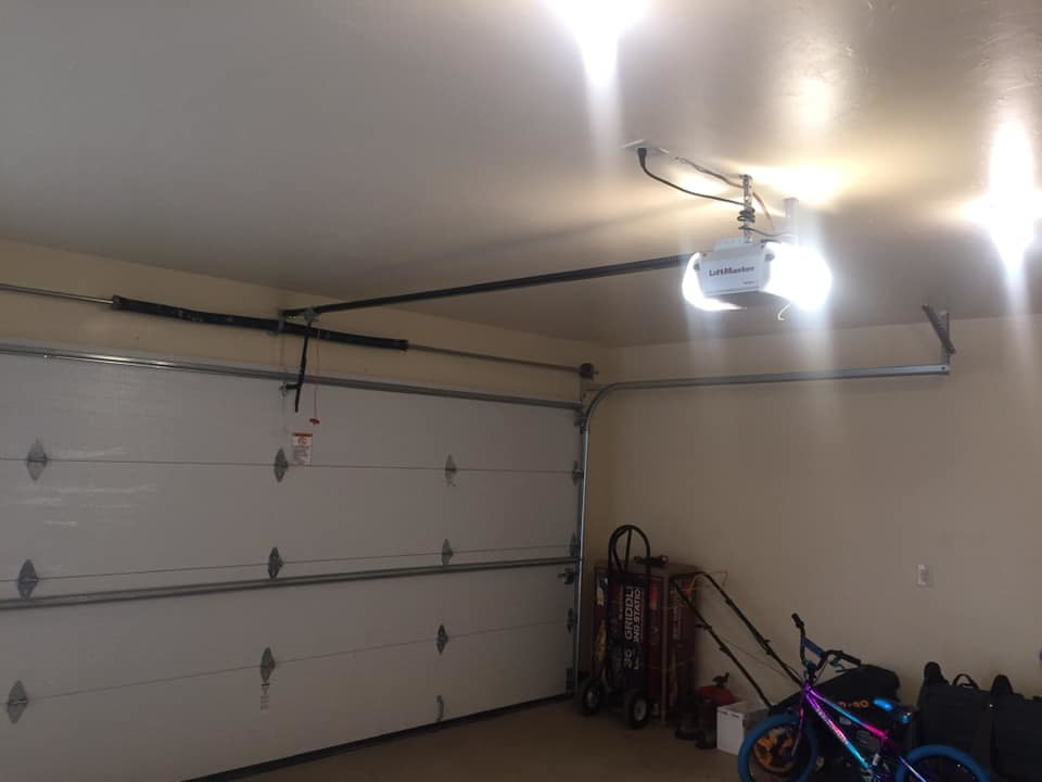 A newly installed white garage door and LiftMaster opener inside a garage by Big Red Overhead Door, LLC in Moore, OK.