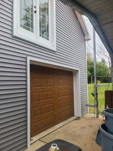 New garage door and gray siding installation by Jos Construction LLC in Trenton, NJ.