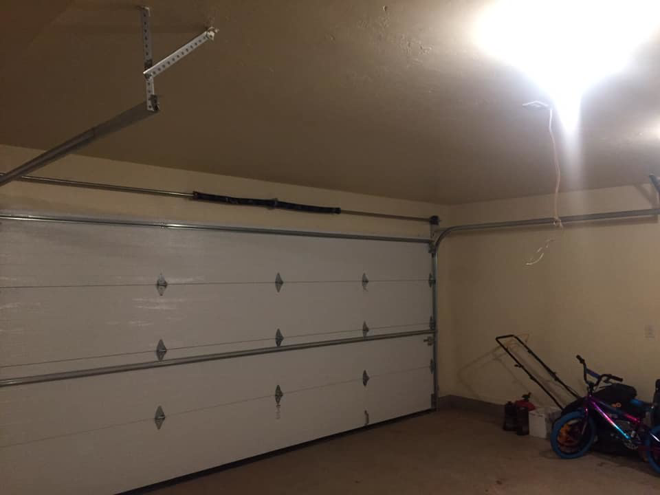 Interior view of a white garage door with tracks and springs installed by Big Red Overhead Door, LLC in Moore, OK.