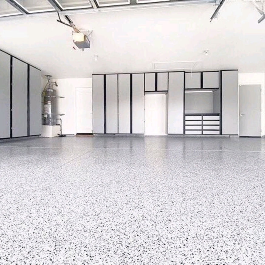 A clean garage featuring a new epoxy floor coating and custom storage cabinets by CJD General Contracting, LLC in Kansas City, MO.