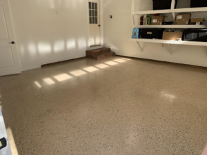 A clean garage with a new epoxy floor coating and installed wall shelving by Carolina Handyman Builder in Taylors, SC.
