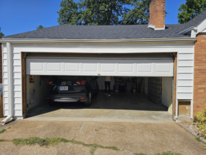 The exterior of a garage with a partially open door, before renovation by AIS Home Service's in St. Louis, MO.