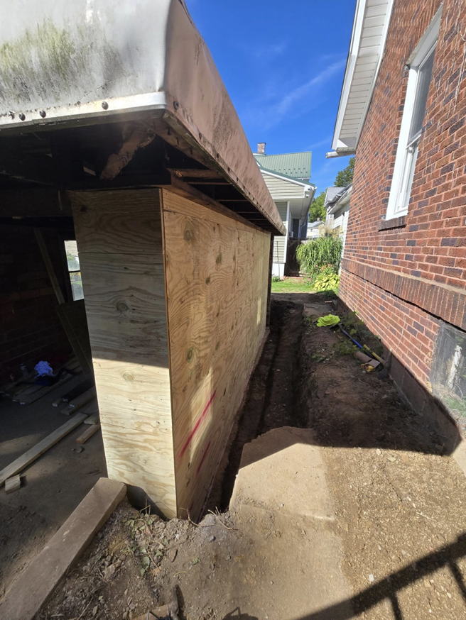 Exterior view of a garage under construction with new plywood sheathing by Crowned Creations in Erie, PA