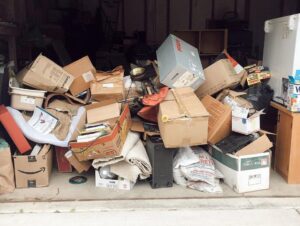 A garage filled with numerous cardboard boxes and miscellaneous junk items, ready for removal by Junk Hunks 406 in Missoula, MT.