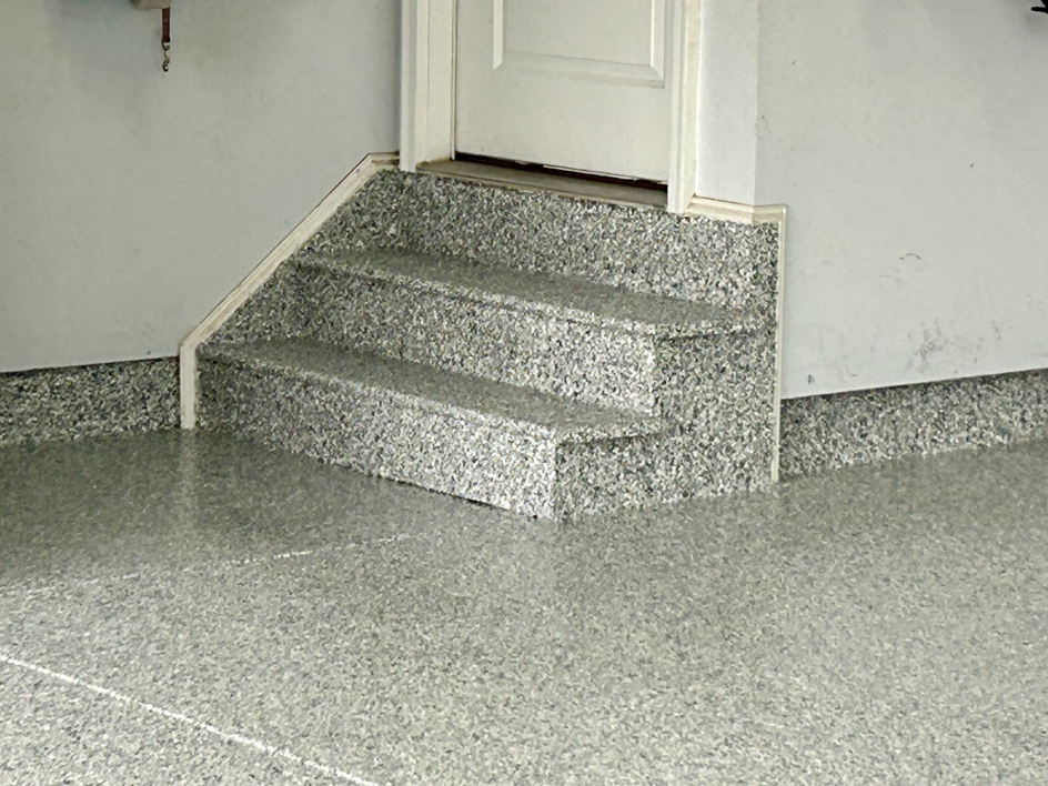 Close-up of a garage floor and steps with a durable epoxy coating by Garage Upgrade Pros in Fort Mill, SC.