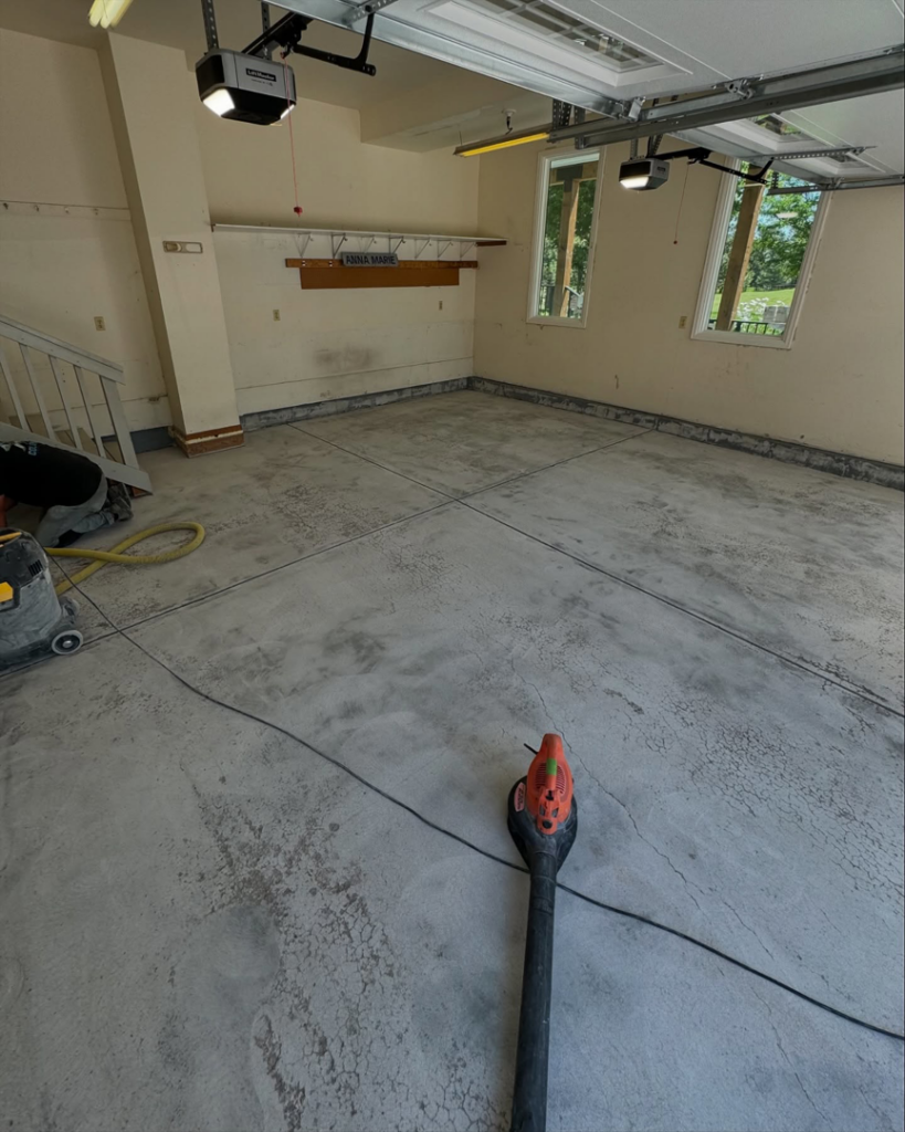 A worker preparing a garage floor for custom coating by Apex Custom Coatings in Middleton, WI