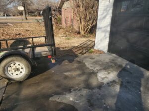 A garage floor covered with trash bags, boxes, and various items, ready for junk removal by Urban Junk Removal, LLC in Springdale, AR.