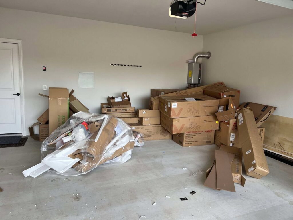 A garage filled with numerous cardboard boxes and other junk, awaiting removal by Cowtown Waste Removal in Fort Worth, TX.