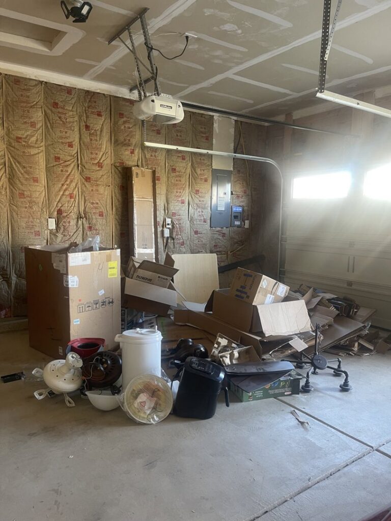 A garage filled with numerous boxes and various items, indicating a junk removal service by Indy Trash Guy in Fishers, IN.