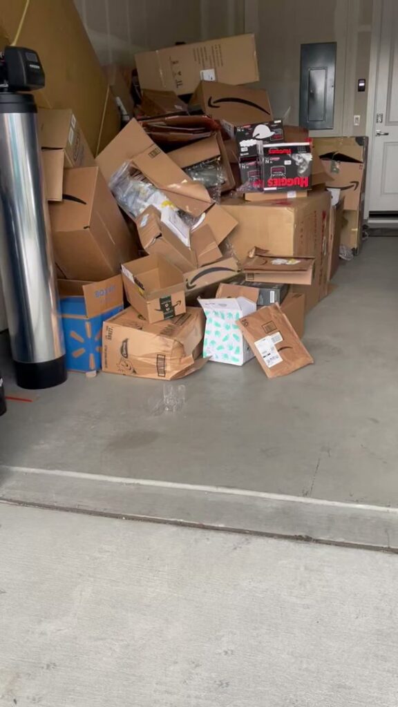 A garage cluttered with numerous cardboard boxes and other items, awaiting junk removal by Nixxit Junk Removal in Castro Valley, CA.