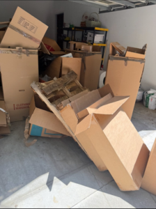 A garage filled with numerous cardboard boxes and wooden pallets, ready for removal by 247 Junk Removal Greenville SC in Greenville, SC.