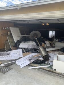 A garage overflowing with construction debris, black trash bags, and various junk, ready for removal by We-Haul Junk Removal in Long Beach, CA