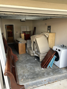A garage filled with old furniture and household junk ready for removal by Just Dump It in Jacksonville, FL.