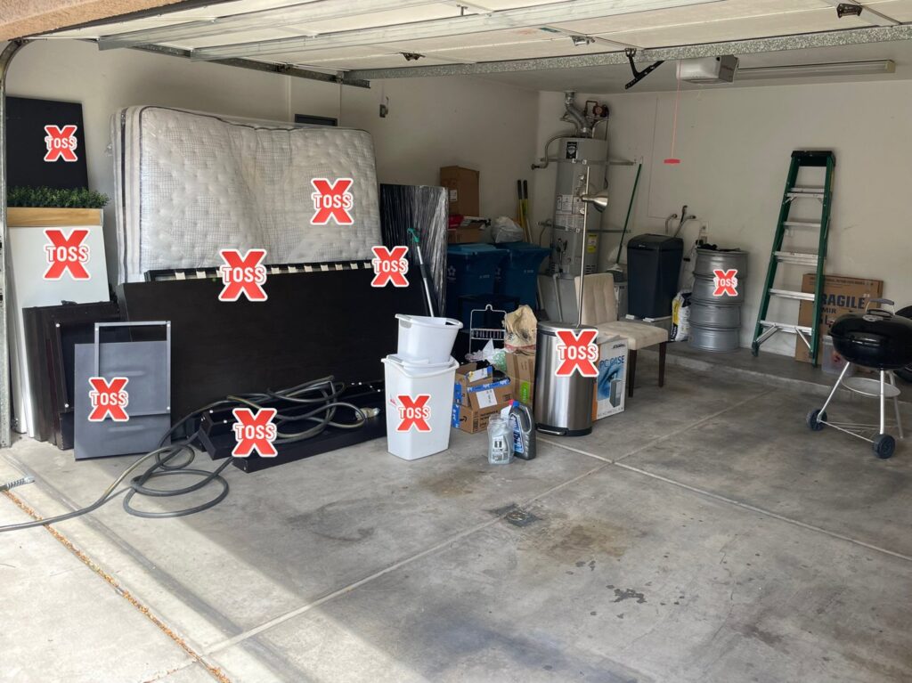 A garage full of various items, many marked with 'TOSS', indicating junk removal by Tidy Toss Las Vegas, NV.
