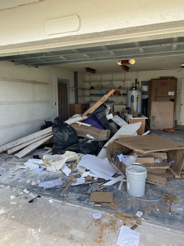 A garage filled with various junk, trash bags, and construction debris, ready for removal by Anthony's Junk Removal & Delivery LLC in Cape Coral, FL.