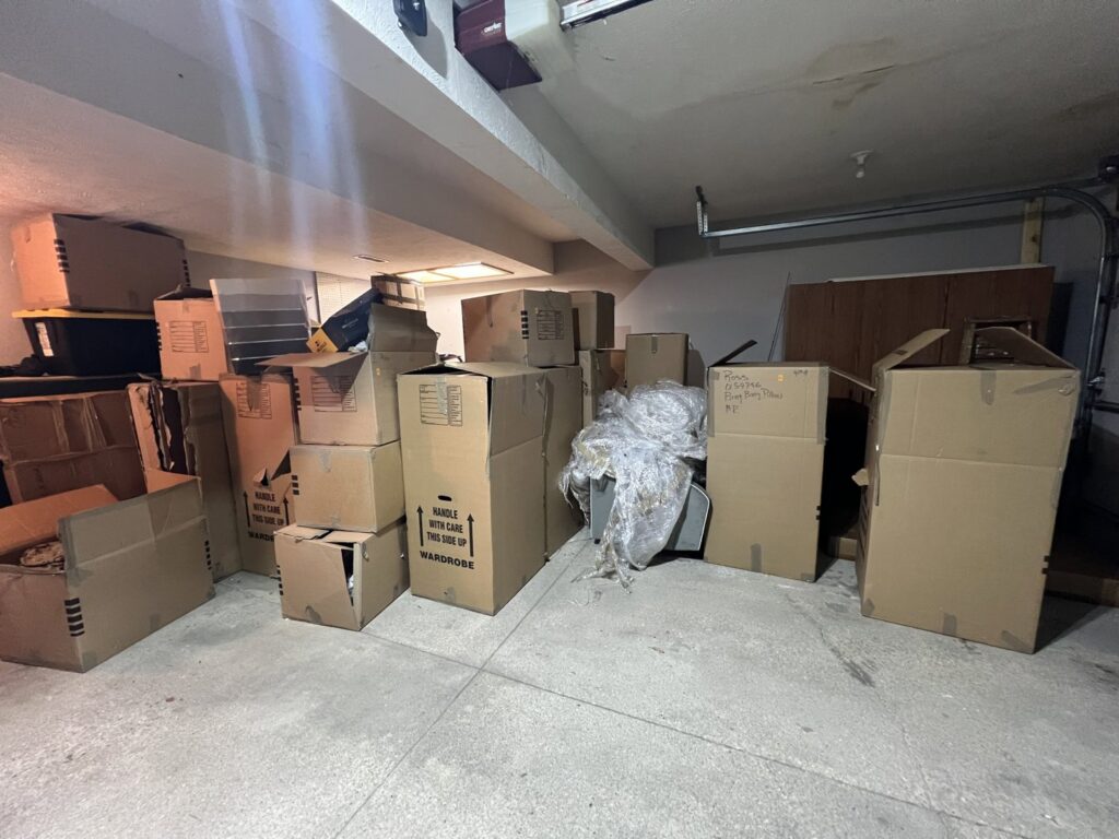 A garage packed with moving boxes and items, indicating a cleanout or removal service by Midwest Removal in Omaha, NE.
