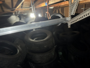 A garage packed full of old tires, indicating a large-scale junk removal job by TRS Roll-Offs LLC in Canton, OH.