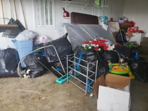 A garage or storage area filled with trash bags, boxes, and household clutter for Sonny Day Junk Removal in Batesville, AR.