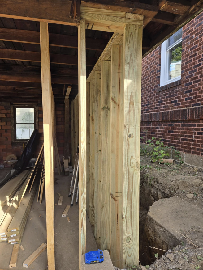 Interior view of a garage showing new wood framing and construction work by Crowned Creations in Erie, PA