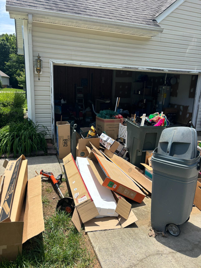 A pile of cardboard boxes and debris outside a garage, ready for junk removal by Allen's Junk Removal & Hauling in Smyrna, TN.