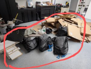 A pile of cardboard boxes and trash bags in a garage, ready for junk removal by 1-800-GOT-JUNK? in Bronx, NY