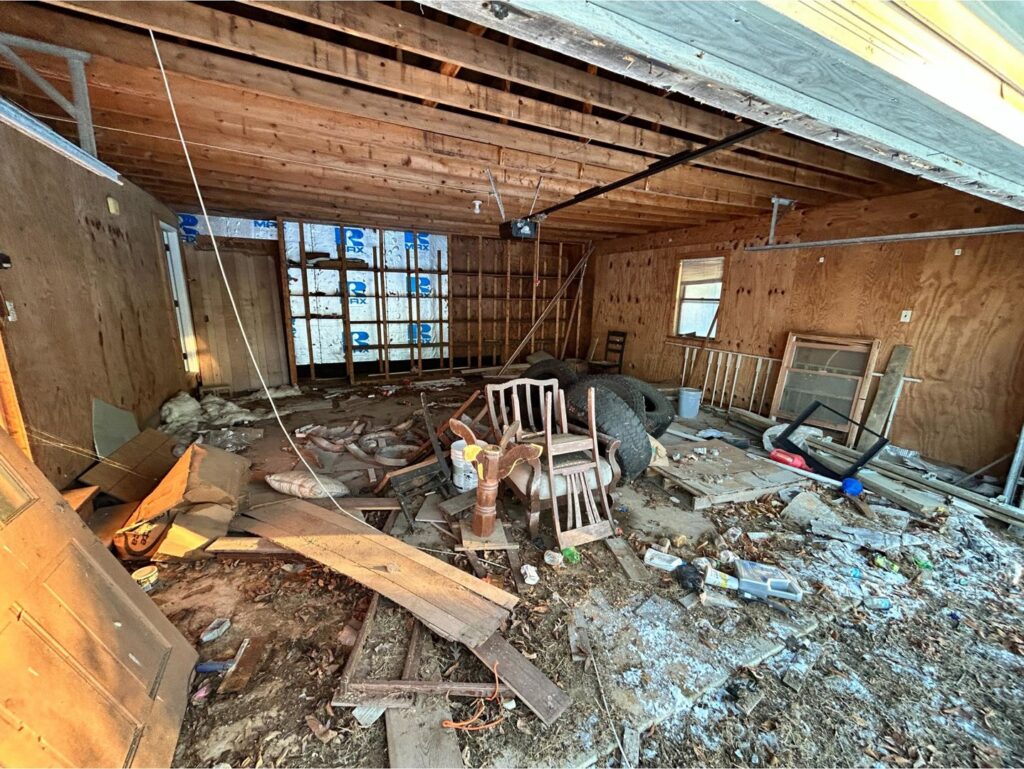 Cluttered garage interior with various junk items for removal by Insta Junk Removal & Demolition LLC in Salisbury, MD