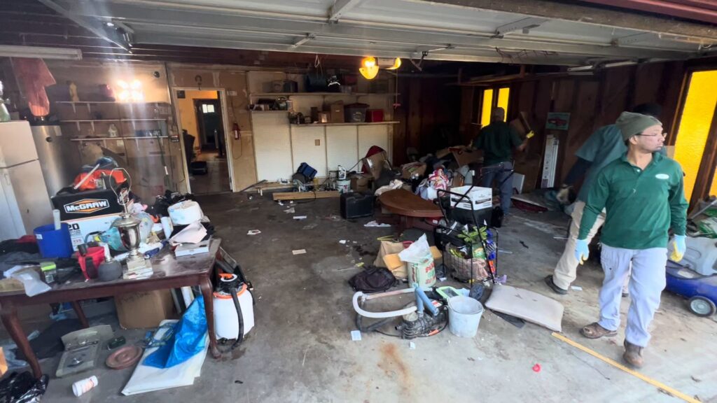 Sac Junk employees removing a large amount of junk from a cluttered garage in Rancho Cordova, CA