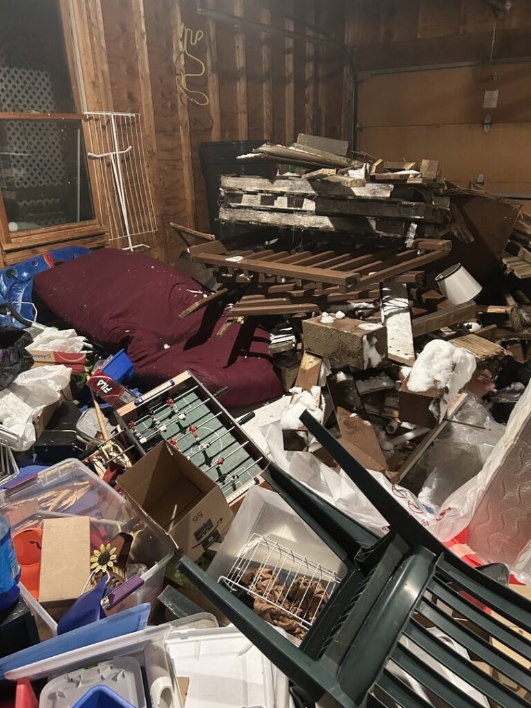 A cluttered garage full of various junk ready for removal by Junk Dunkers in Wrentham, MA