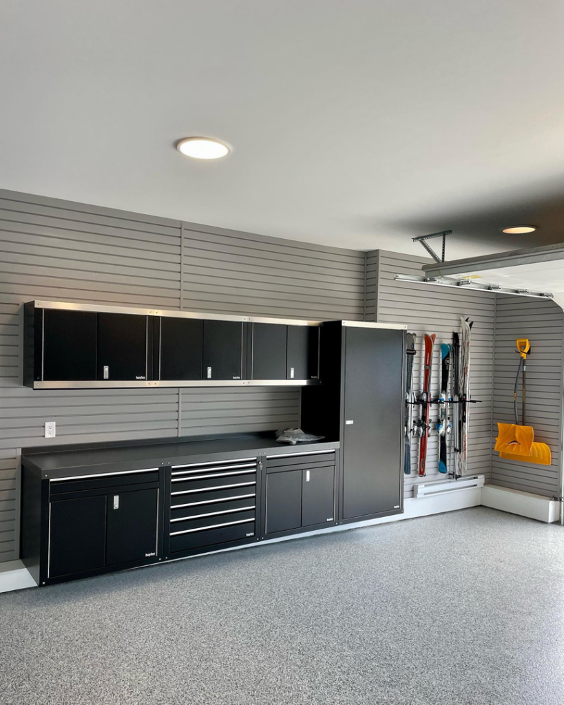 A well-organized garage with custom cabinets, slatwall, and new flooring by Construction Components in Puyallup, WA.