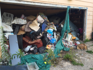 A cluttered garage overflowing with various items and debris, ready for cleanup by ECO Junk Removal in Duluth, MN.
