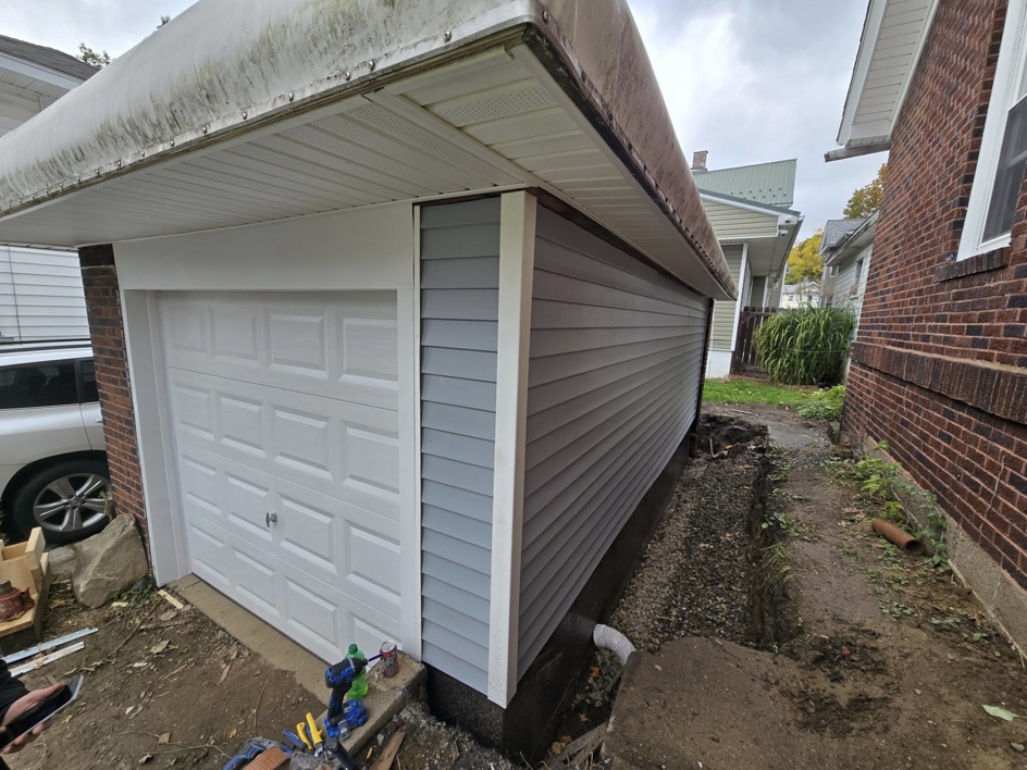 Newly installed siding and garage door on a residential garage by Crowned Creations in Erie, PA