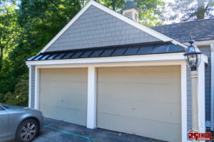 A garage with new siding and a stylish metal roof accent installed by Mendez Contractor Inc in Lynn, MA