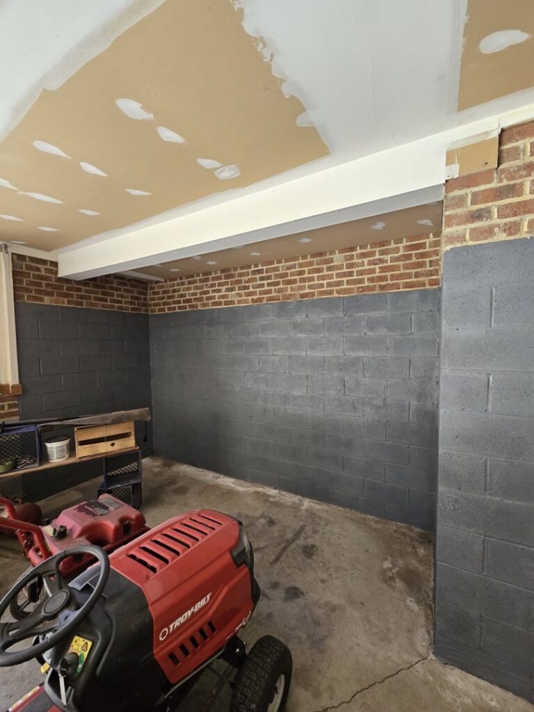 Garage interior showing painted cinder block walls and partially finished drywall ceiling by Home FREA in Raleigh, NC.