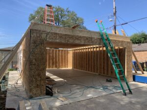 A garage under construction with wall framing and initial roof structure by A-Windy City Garages & Doors in Chicago, IL.