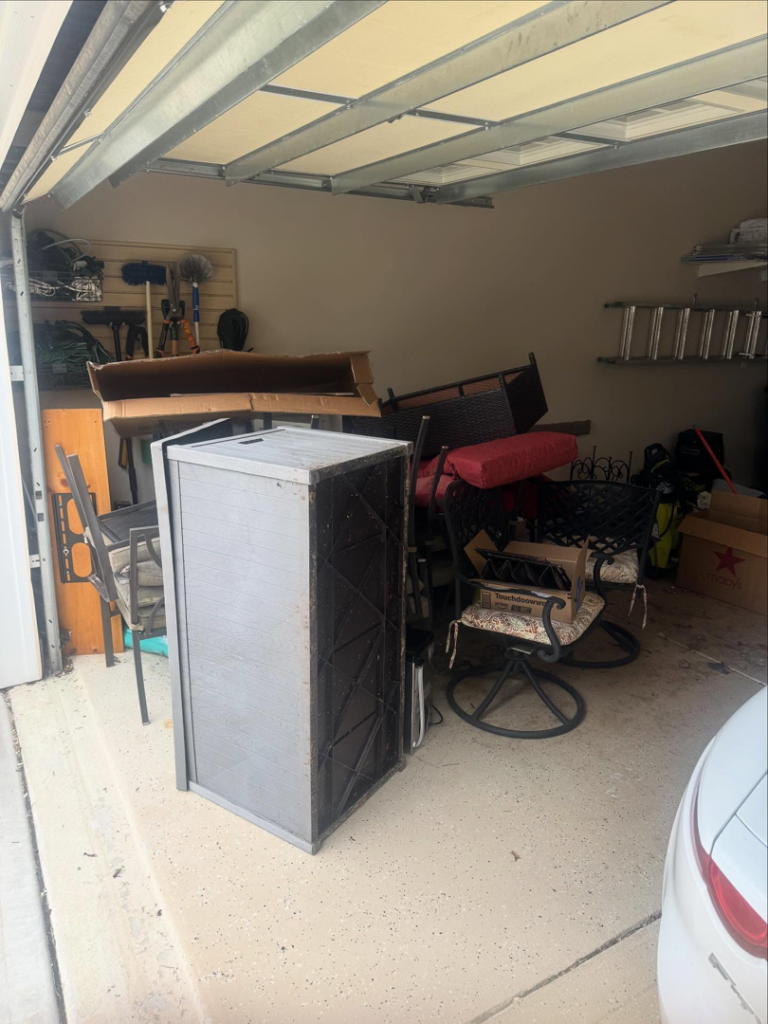 A garage with outdoor furniture and other items awaiting junk removal service from Dumpzilla in Raleigh, NC.