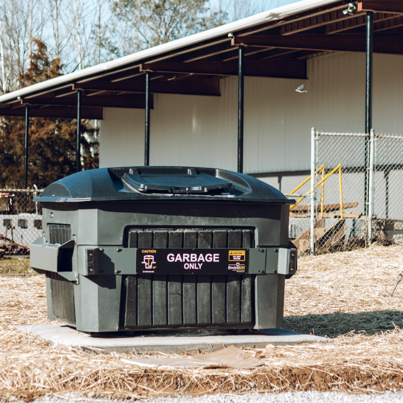 A branded 'GARBAGE ONLY' waste bin in an outdoor setting from Binova Group in Knoxville, TN.