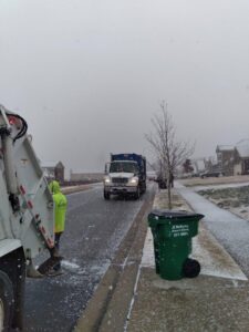 A J.E. McMurtry Disposal & Recycling garbage truck and a worker on a snowy residential street in Nashville, TN.