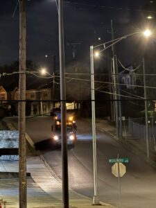 A J.E. McMurtry Disposal & Recycling garbage truck driving down a street at night in Nashville, TN.